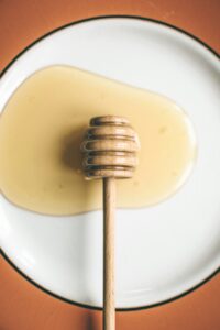 Honey dipper on a plate of honey